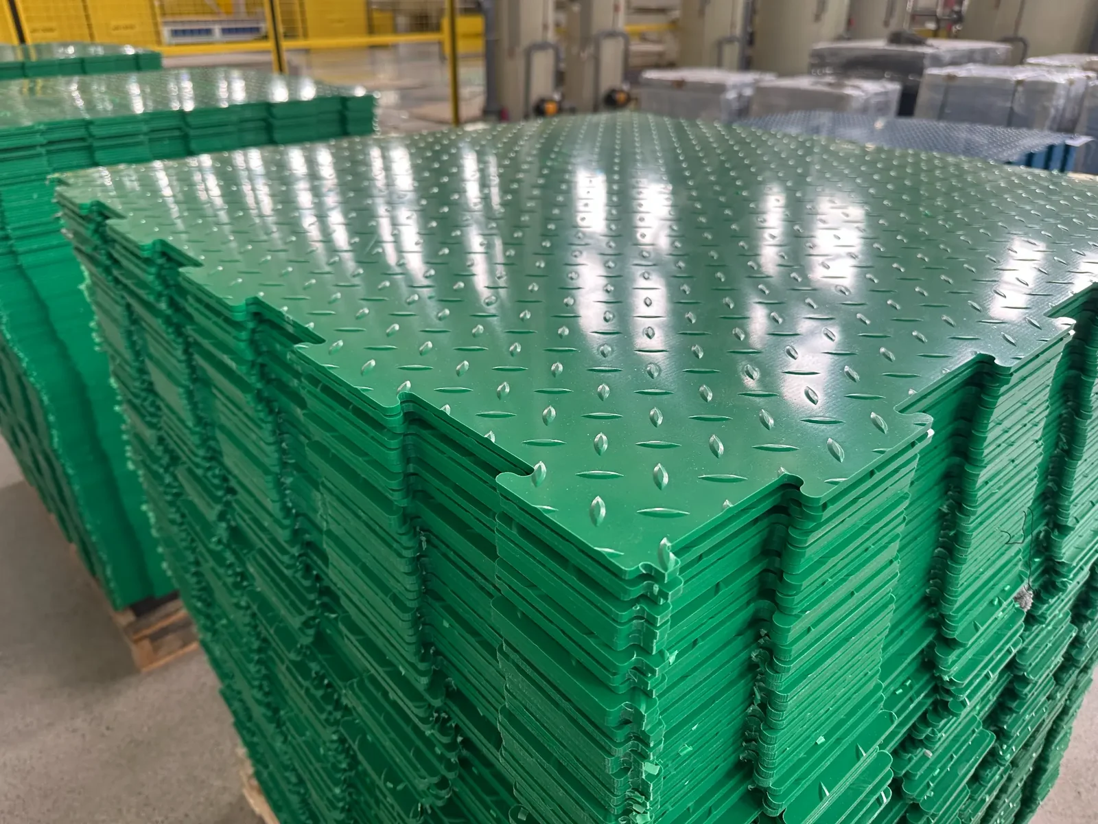 Company-supplied factory photo: green panel stack with interlocking-edge view.
